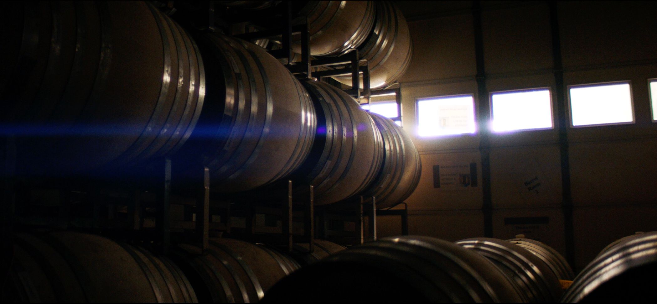 Stacked oak barrels in the Domaine Della cellar