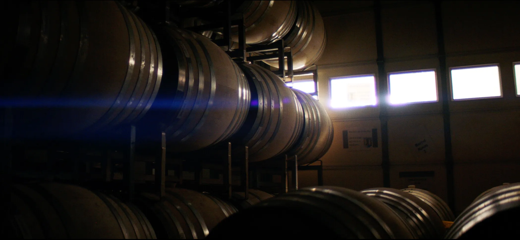 Stacked oak barrels in the Domaine Della cellar